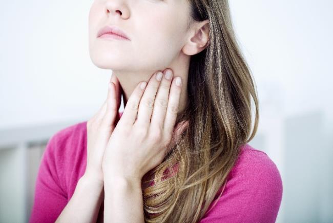 אישה בודקת את בלוטות הלימפה הצוואריות